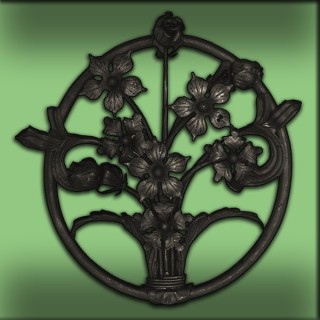 Bouquet de fleurs décoratif en fer forgé inscrit dans un cercle ovale pour être accroché à un mur